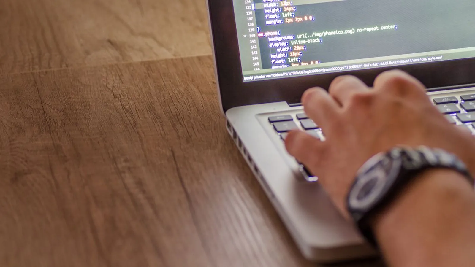 Close-up of a person coding on a laptop, showcasing web development and programming concepts.