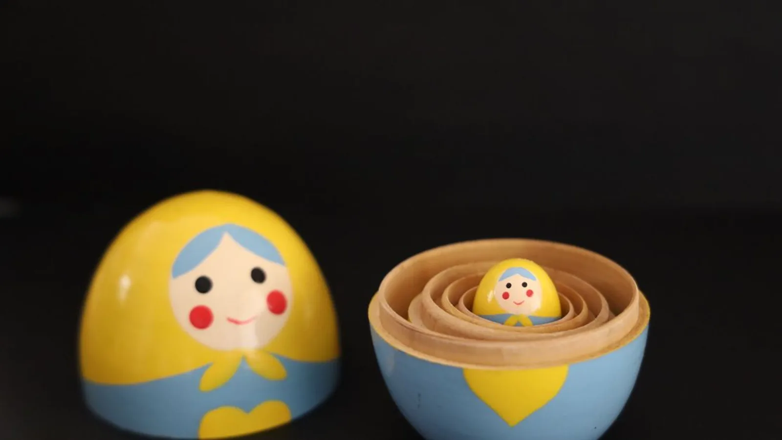 Colorful Matryoshka dolls on black background, showcasing Russian craftsmanship.