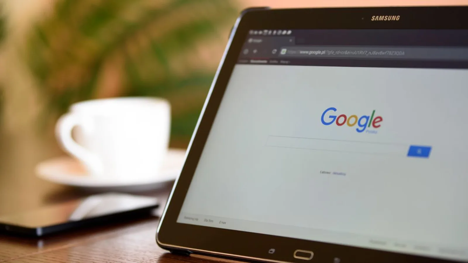 Samsung tablet on desk showing Google homepage, perfect for technology-related content.